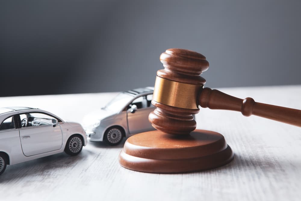 Image of cars and a judge's gavel, symbolizing legal proceedings related to car accidents.